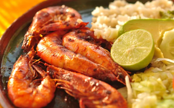 A vibrant HD desktop wallpaper featuring a delicious meal of grilled shrimp served with lime and rice, capturing the essence of appetizing food.