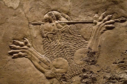 Artistic Assyrian lion-hunt stone relief: a warrior spearing a lion, detailed carved textures — HD PC desktop wallpaper/background.