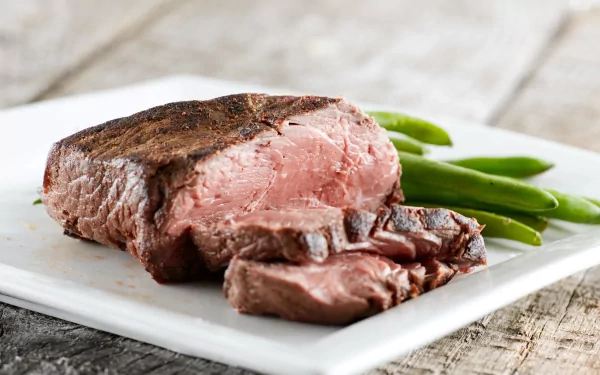 4K Ultra HD desktop wallpaper featuring a juicy, medium-rare steak sliced on a white plate with green beans, emphasizing rich textures and vibrant colors.