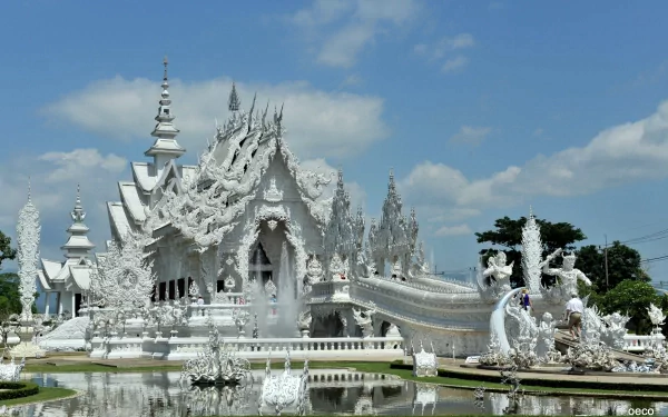 A 4K Ultra HD desktop wallpaper of Wat Rong Khun, a stunning white religious temple with intricate, ornate architecture under a bright blue sky.