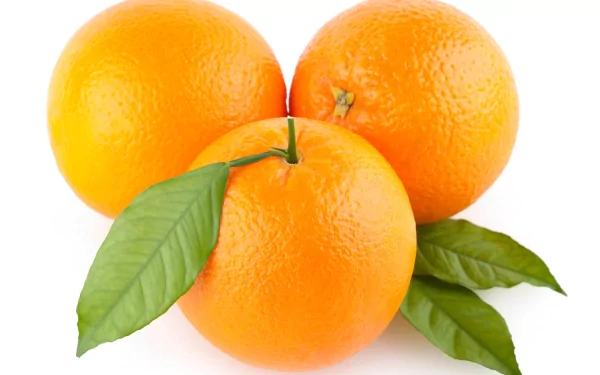 A vibrant 4K Ultra HD desktop wallpaper featuring three fresh, bright orange oranges with green leaves against a clean white background.