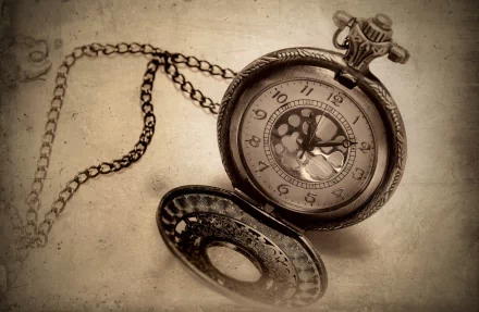 A close-up of an antique pocket watch with intricate details, set against a textured background. This HD image serves as a striking desktop wallpaper.