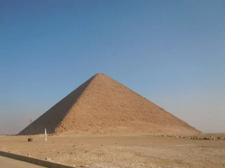 HD PC desktop wallpaper of a man-made pyramid rising from a sunlit desert beneath a clear blue sky.