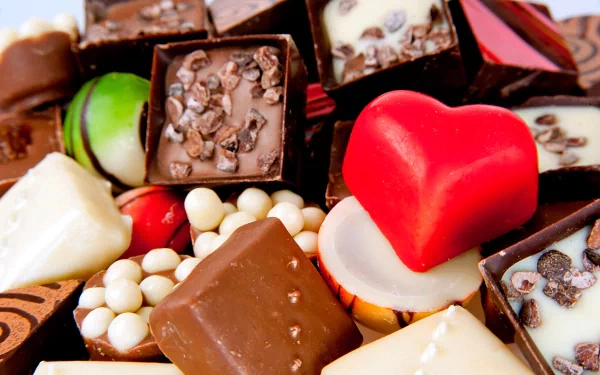 A vibrant 4K Ultra HD PC desktop wallpaper featuring an assortment of assorted chocolates and colorful confectionery, including a red heart-shaped piece.