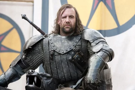 Rory McCann as Sandor Clegane in Game of Thrones, captured in a striking HD wallpaper featuring the formidable character in detailed armor. A dramatic backdrop enhances the scene.