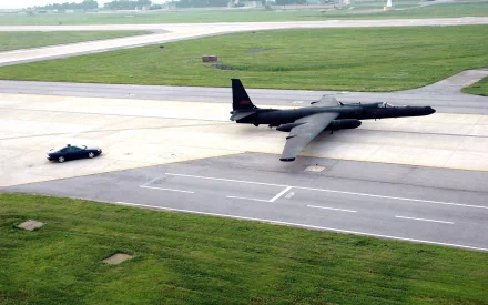 Military Lockheed U-2 spy plane taxiing on a runway beside a chase car — 2K Quad HD PC desktop wallpaper background