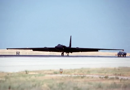 Lockheed U-2 military reconnaissance aircraft on runway with support vehicle, widespan silhouette under clear sky — 2K Quad HD PC desktop wallpaper/background.
