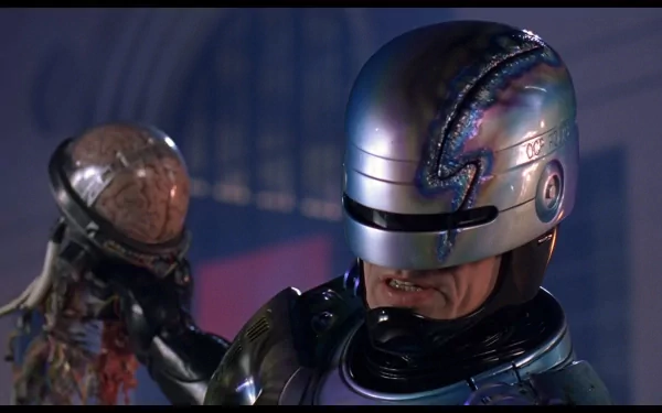 HD PC desktop wallpaper featuring RoboCop from the movie RoboCop 2, showcasing the iconic armored cyborg in a dimly lit setting holding a damaged robotic head.
