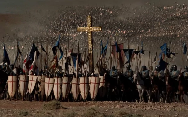 HD PC desktop wallpaper: battle scene from the movie Kingdom of Heaven — crusader shield wall with banners and a large golden cross rising above a dusty battlefield.