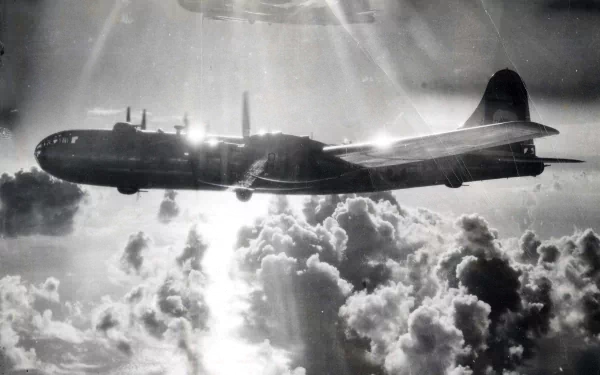 Black and white HD desktop wallpaper featuring a Boeing B-29 Superfortress flying above dramatic clouds, showcasing its military design and historic significance.