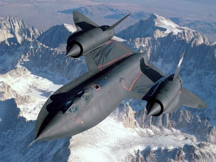 HD desktop wallpaper featuring the Lockheed SR-71 Blackbird, a sleek military reconnaissance aircraft soaring above rugged mountain peaks.