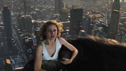 Naomi Watts in a dramatic scene from the movie King Kong (2005), set against a panoramic view of a city skyline. The image serves as a striking HD wallpaper.