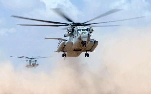 HD desktop wallpaper featuring two military Sikorsky MH-53 helicopters flying low over a dusty terrain with rotors in motion.