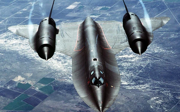 A stunning HD wallpaper featuring the Lockheed SR-71 Blackbird soaring above a patchwork landscape, showcasing its sleek design and military prowess.