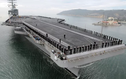 A 4K Ultra HD image of the USS Ronald Reagan (CVN-76) aircraft carrier at sea, showcasing the military warship's expansive flight deck and crew lined along the edges.