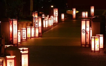 HD desktop wallpaper featuring a pathway illuminated by traditional man-made lanterns glowing warmly in the night.