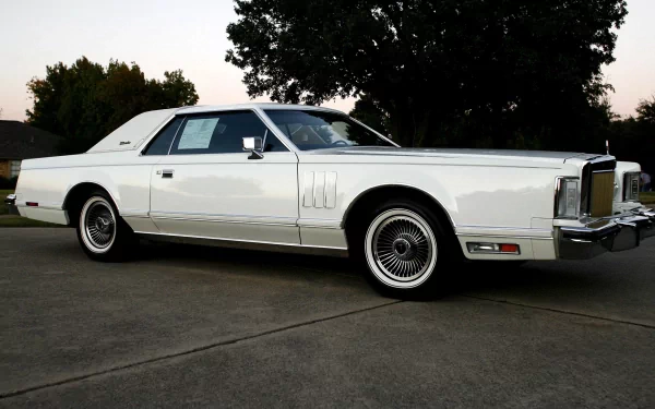 HD desktop wallpaper featuring a classic white Lincoln Continental Mark V parked on a driveway at dusk.