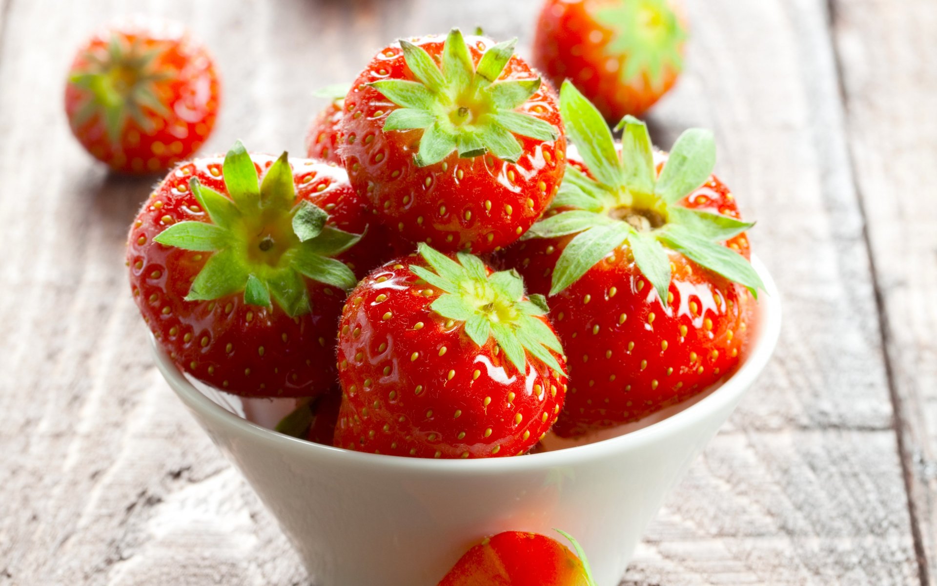 HD PC desktop wallpaper featuring a close-up of fresh, ripe strawberries in a white bowl on a rustic wooden surface.