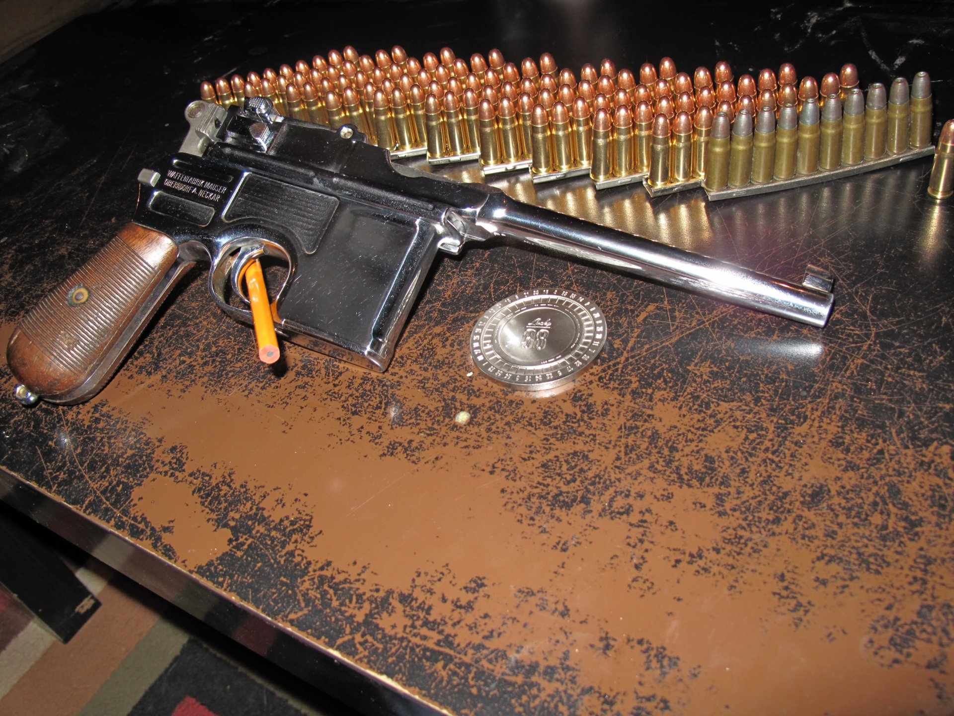 A high-definition desktop wallpaper featuring a man-made Mauser pistol, resting on a distressed surface alongside a row of ammunition, capturing a striking and detailed composition.