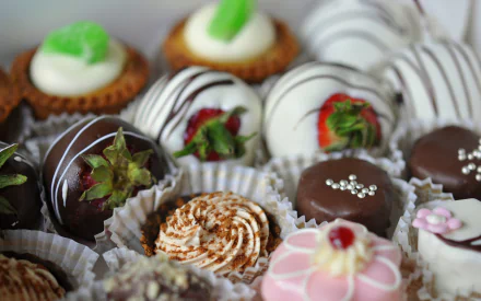 A tempting assortment of chocolates and desserts, elegantly arranged in paper cups, creating a delectable display for a high-definition desktop wallpaper.