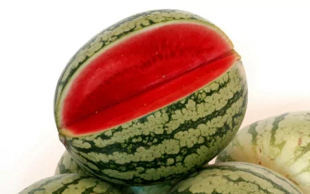 HD PC desktop wallpaper featuring a close-up of a watermelon with a bright red, juicy interior and green striped rind against a white background.
