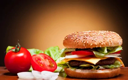 A delicious burger with lettuce, tomato, and cheese sits on a wooden surface, accompanied by fresh tomatoes and onions, creating an appealing HD desktop wallpaper.