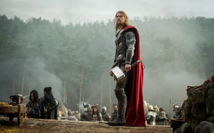 Thor stands confidently with his iconic hammer, Mjolnir, amidst a misty battlefield in a scene from *Thor: The Dark World*, depicted in a high-definition desktop wallpaper.