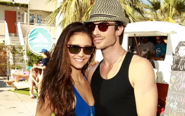 HD PC desktop wallpaper featuring celebrity actor Nina Dobrev and a male companion outdoors with palm trees and sunny weather in the background.