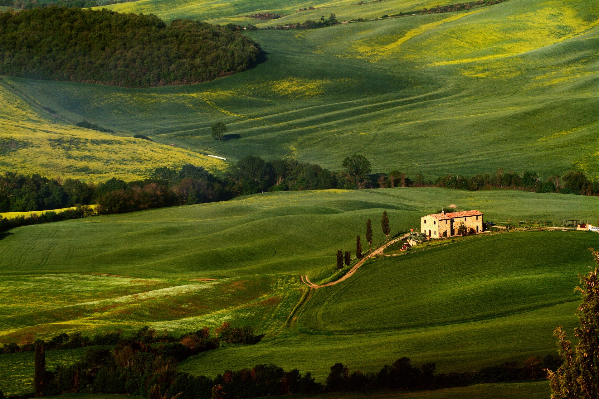 A serene landscape captures rolling green hills and a quaint farmhouse, creating a stunning HD wallpaper and background that embodies nature's beauty.
