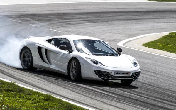 White McLaren MP4-12C supercar drifts on racetrack, captured in high-definition for PC desktop wallpaper and background showcasing the sleek vehicle in action.