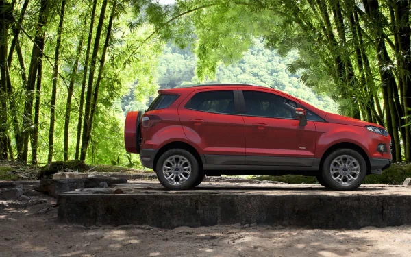HD desktop wallpaper featuring a red Ford EcoSport parked outdoors against a backdrop of lush green bamboo trees.