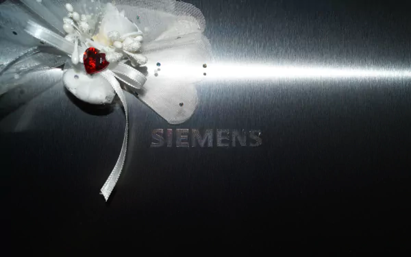 4K Ultra HD desktop wallpaper featuring a metal heart with a red gem and white floral decoration, set against a sleek background with the Siemens logo.