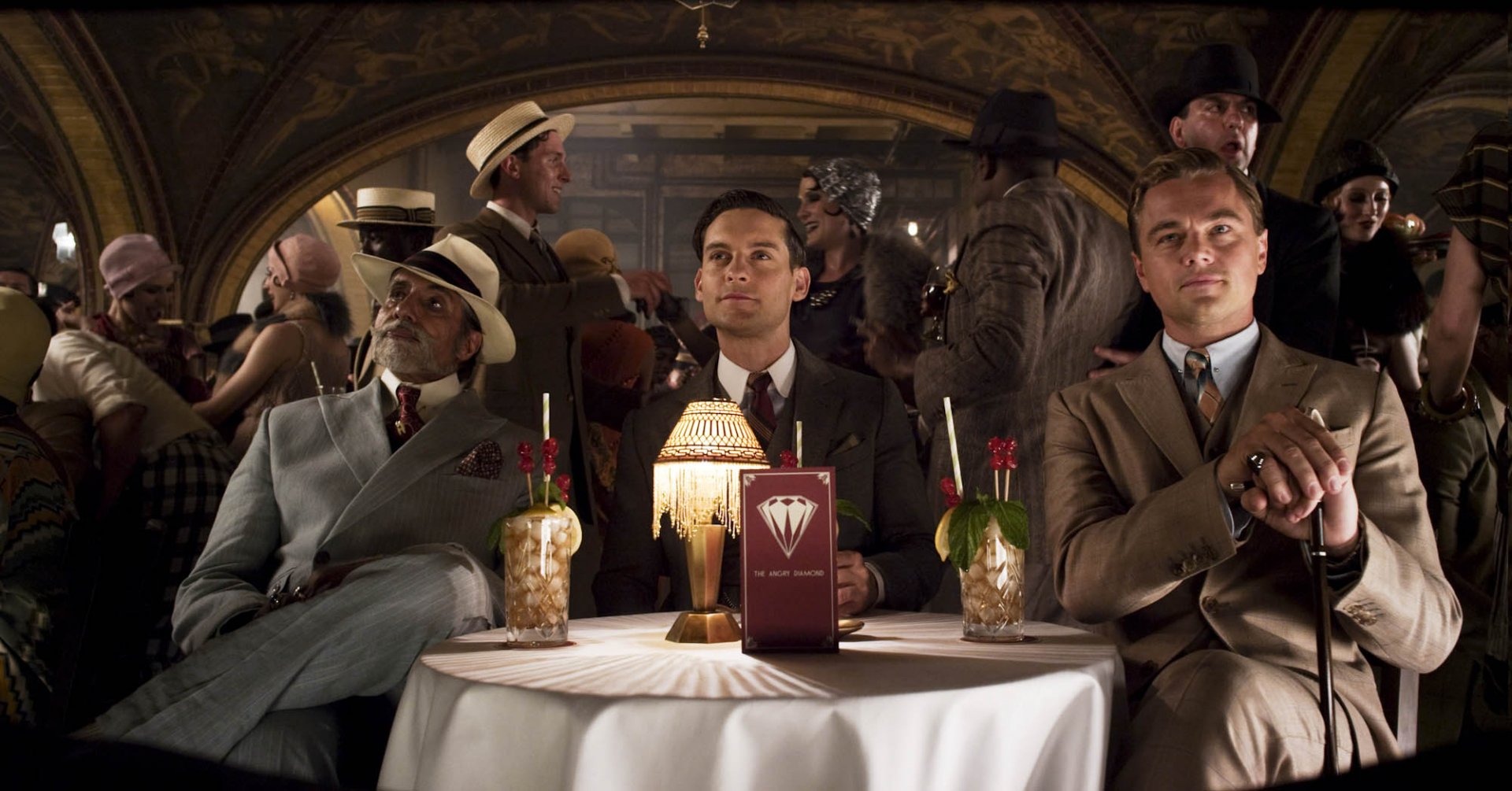 HD desktop wallpaper of Leonardo DiCaprio and Tobey Maguire in a scene from The Great Gatsby, set in a lively 1920s party atmosphere.