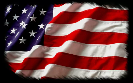 A high-definition wallpaper featuring the American flag, showcasing its vivid red, white, and blue colors with flowing waves that symbolize patriotism and national pride.