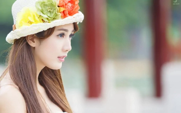 HD desktop wallpaper featuring a close-up of a woman wearing a floral hat, exuding an elegant and serene expression, perfect for a sophisticated background.