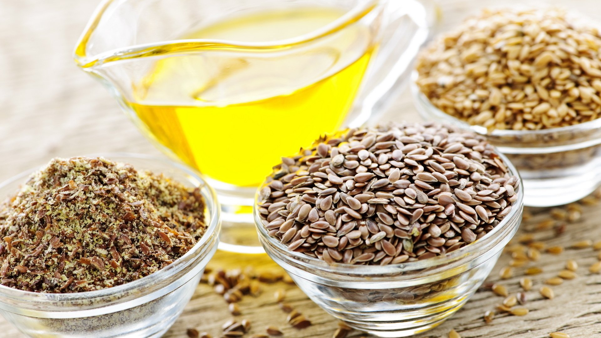 HD PC desktop wallpaper featuring close-up of various seeds and a glass container of golden oil, highlighting natural food ingredients.