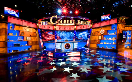 HD wallpaper of The Colbert Report stage with vibrant lighting and star-spangled decor.