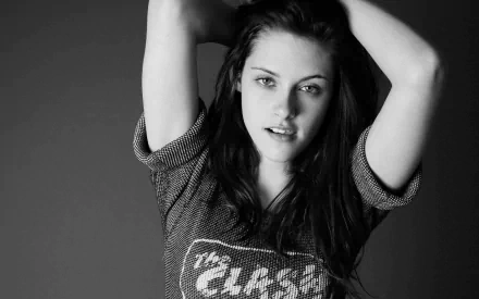 HD desktop wallpaper featuring a black and white portrait of Kristen Stewart in a casual pose with her hands raised.