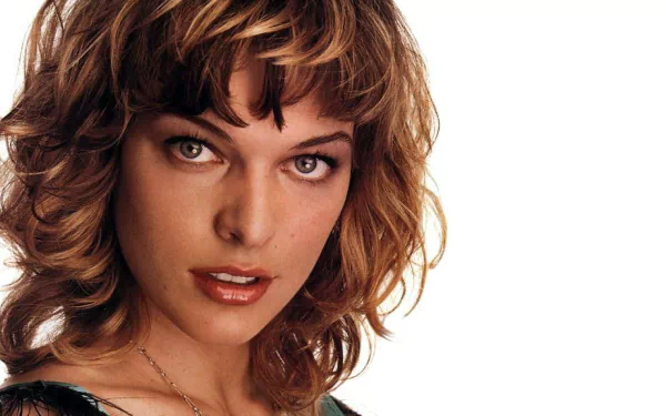 HD desktop wallpaper featuring a close-up portrait of celebrity Milla Jovovich with tousled hair against a white background.