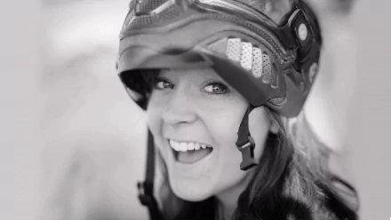 A cheerful woman wearing a helmet smiles brightly, embodying the spirit of music and adventure, set against a stylish HD PC desktop wallpaper background.