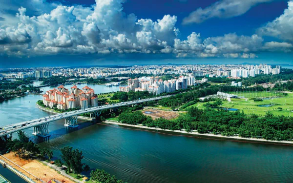 A stunning HD desktop wallpaper showcasing the vibrant skyline and architecture of Singapore, featuring lush greenery, a river, and dramatic clouds overhead.