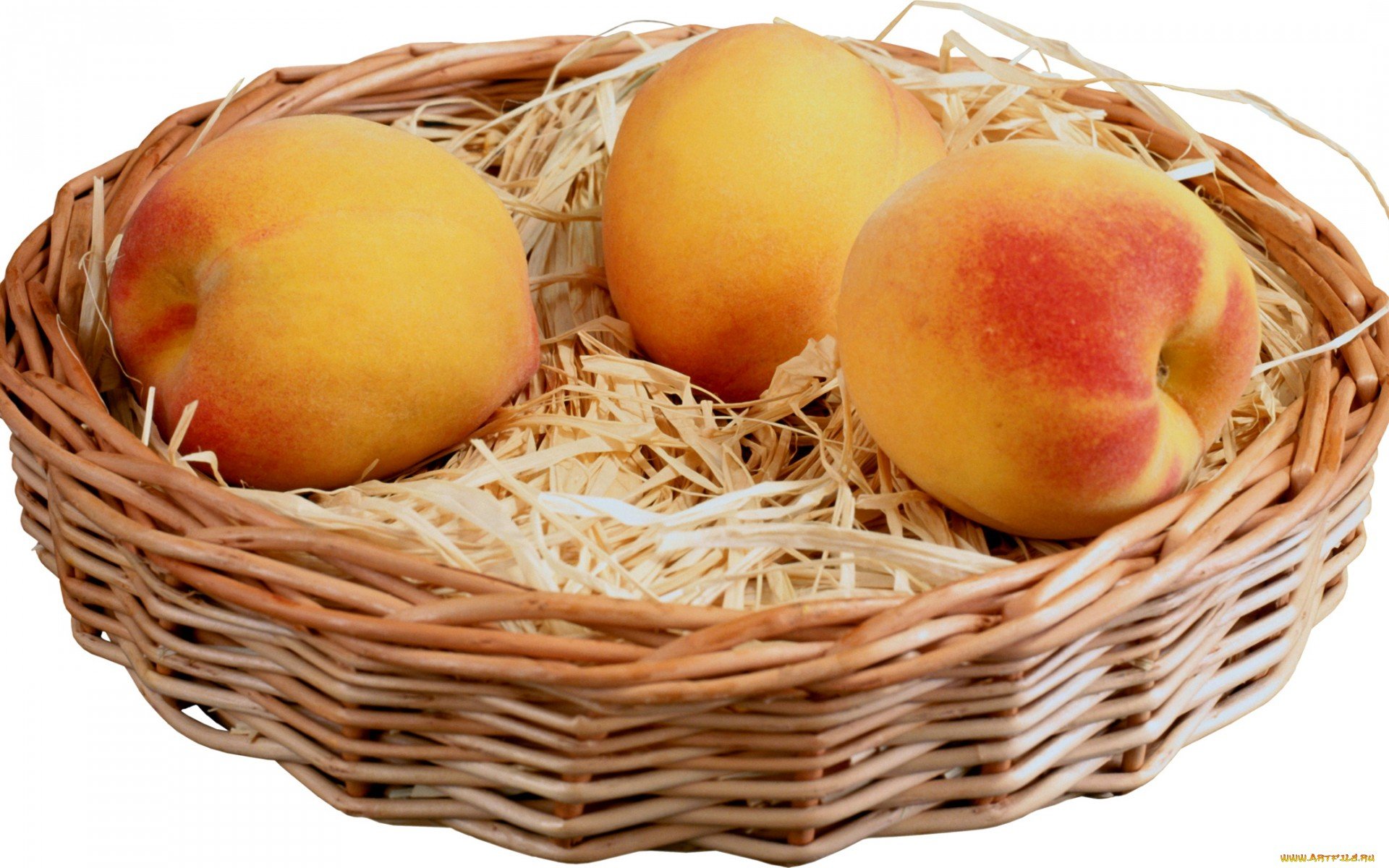 HD PC desktop wallpaper featuring three ripe peaches resting in a woven basket filled with straw, highlighting fresh food and natural textures.
