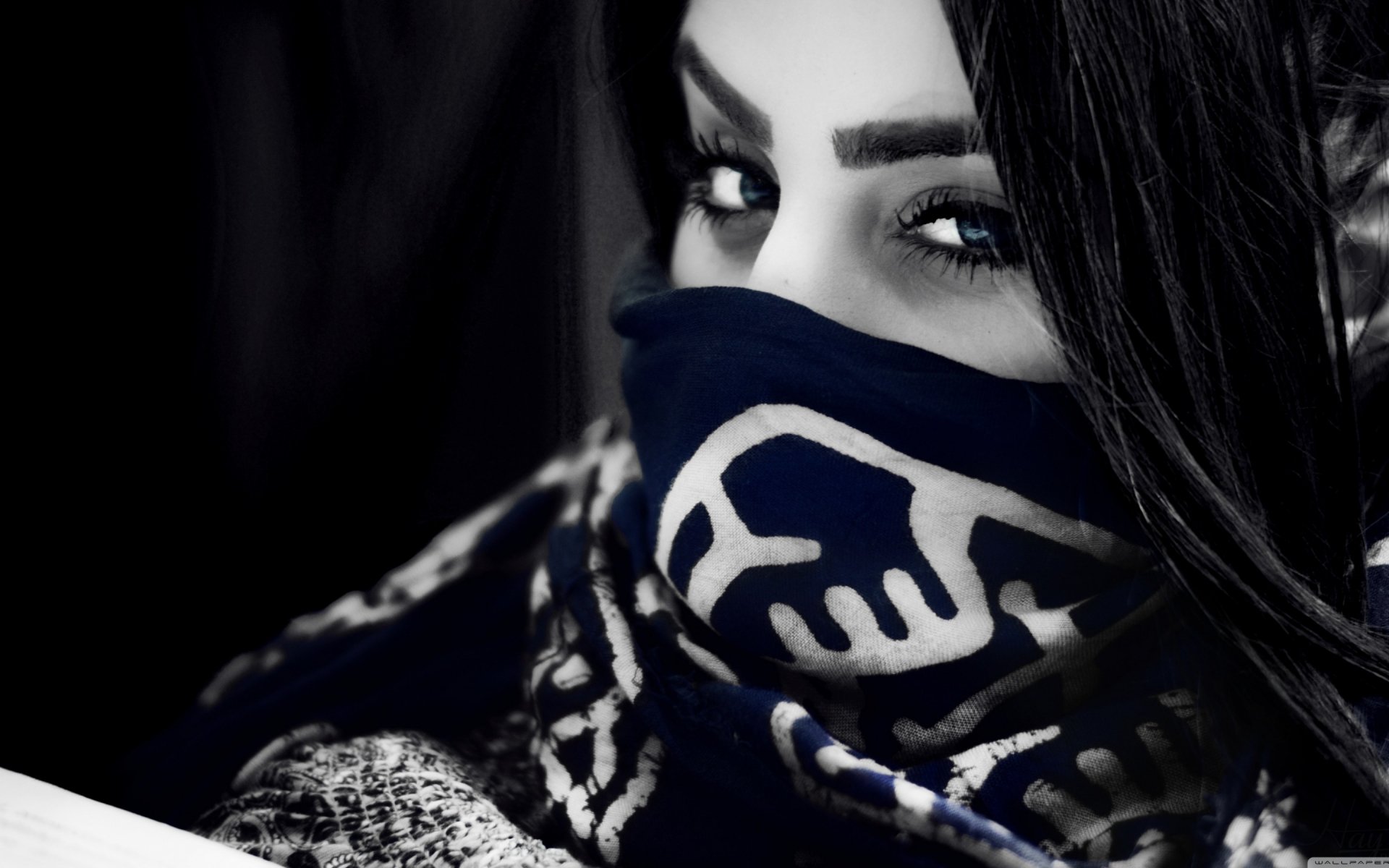 A striking HD desktop wallpaper featuring a close-up of a woman with captivating eyes, partially obscured by a patterned scarf, blending depth and intrigue in monochrome tones.