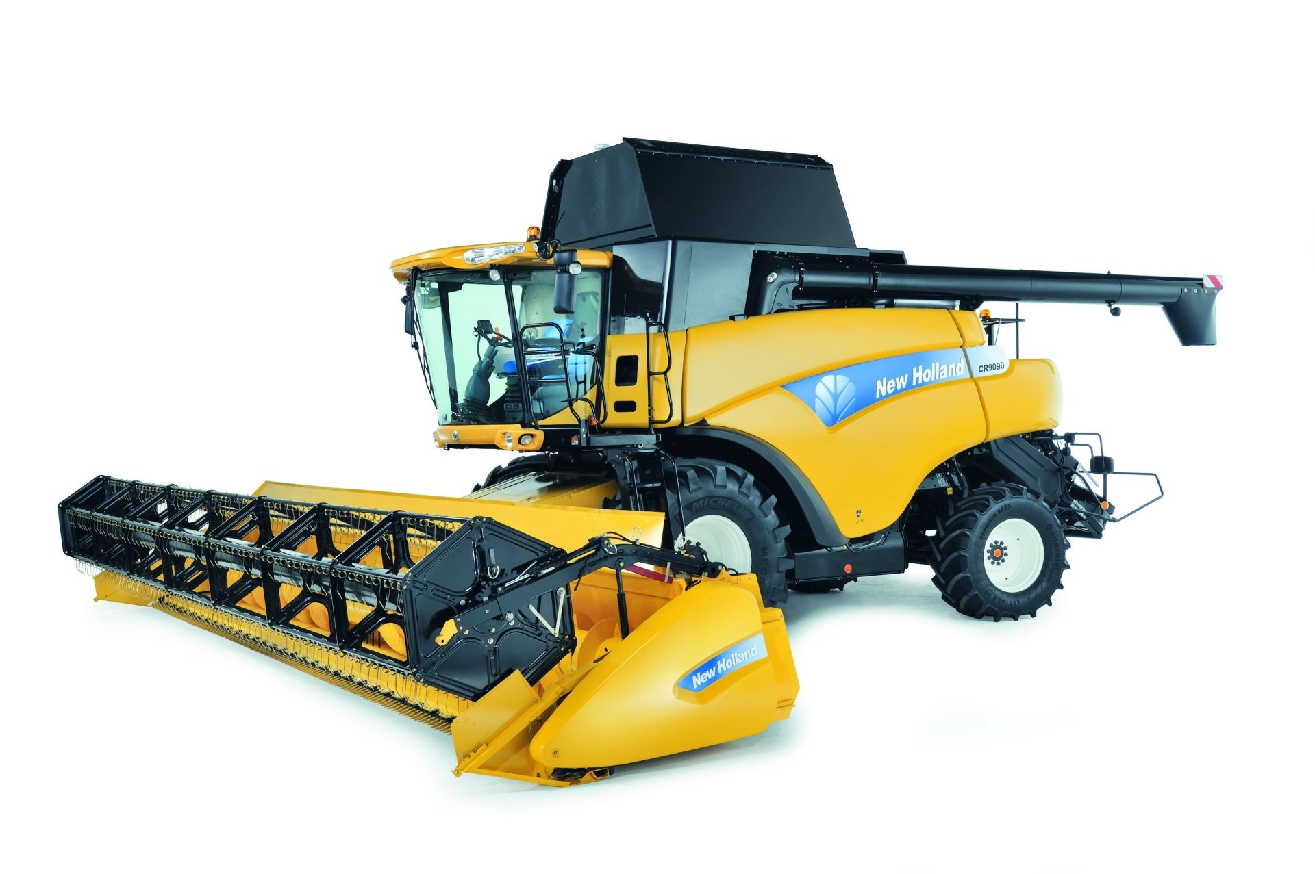 HD desktop wallpaper featuring a yellow New Holland agricultural vehicle with a large black header for harvesting.
