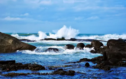 HD PC desktop wallpaper: nature seascape with crashing waves against a rocky shoreline under a bright blue sky.