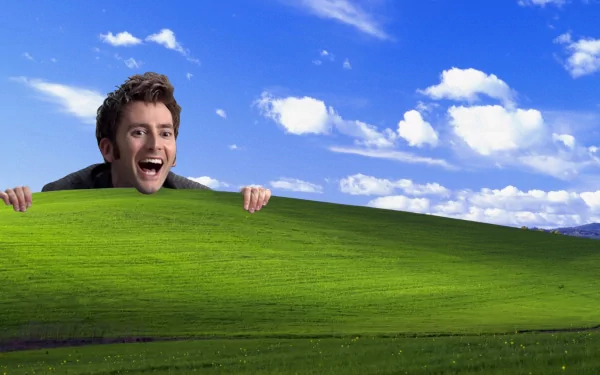 A whimsical HD wallpaper featuring a joyful character from Doctor Who (2005) peeking over a vibrant green hill under a bright blue sky with fluffy clouds.