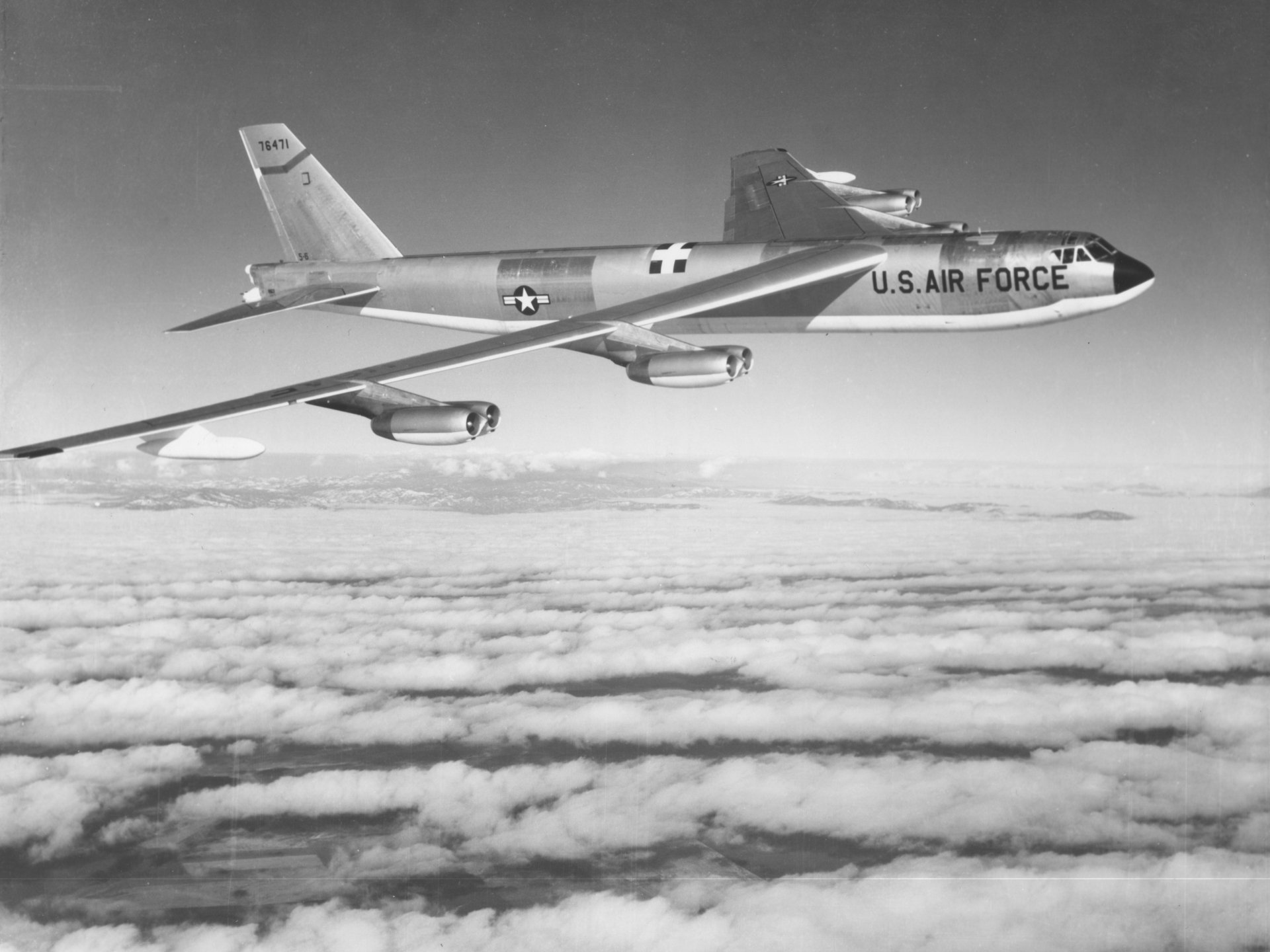A Boeing B-52 Stratofortress from the U.S. Air Force soars above a cloud blanket, captured in striking detail for a military-themed 4K Ultra HD desktop wallpaper.