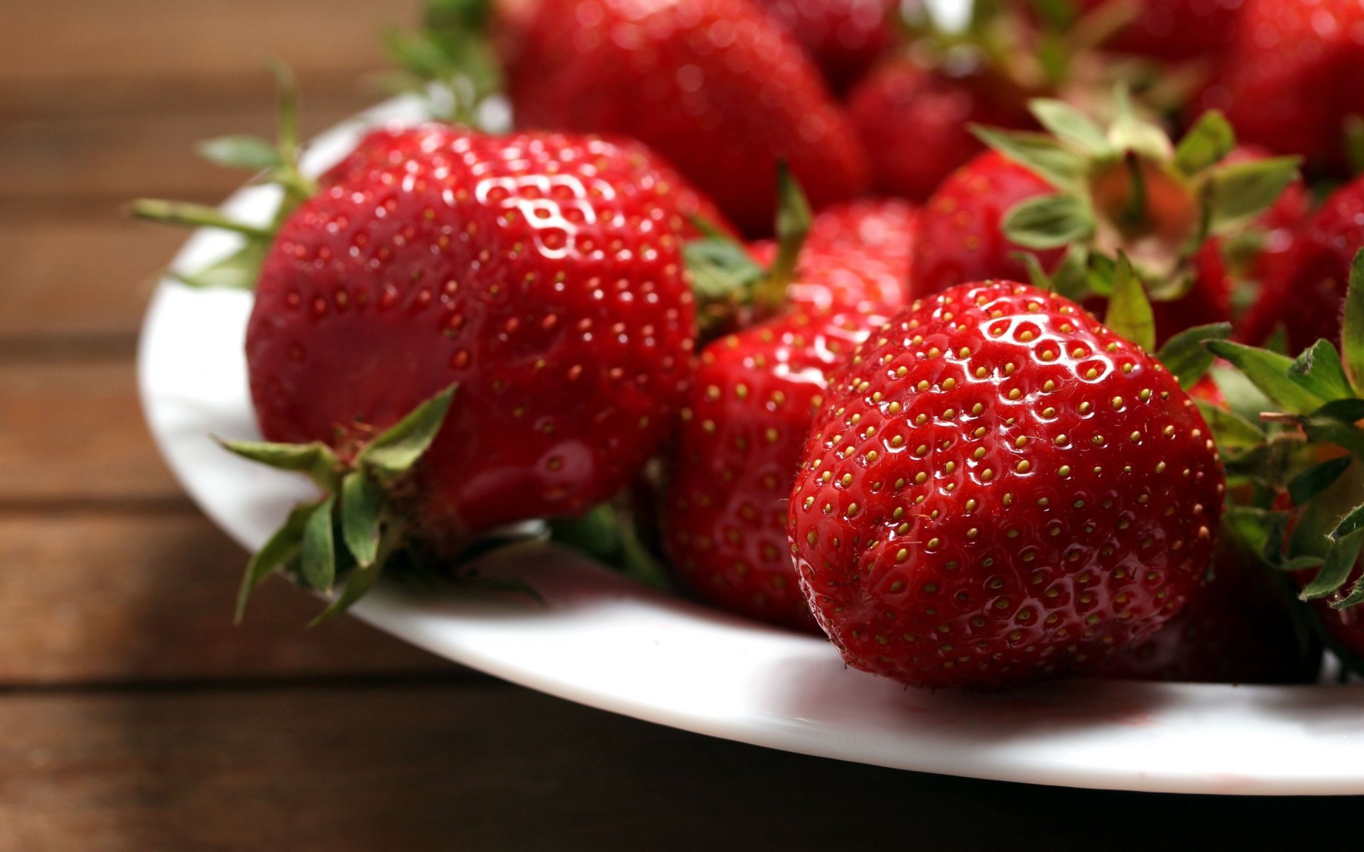 Close-up of fresh strawberries on a white plate, captured in HD quality, displayed as a vibrant PC desktop wallpaper and background featuring food and strawberries.