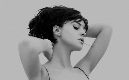 Monica Bellucci poses elegantly, her hair styled gracefully. This black-and-white HD wallpaper captures her timeless beauty, showcasing a classic and sophisticated aesthetic.