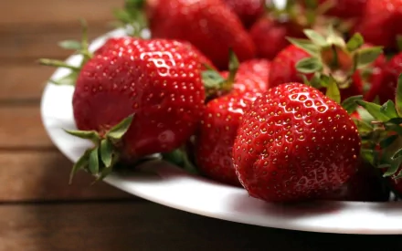 Close-up of fresh strawberries on a white plate, captured in HD quality, displayed as a vibrant PC desktop wallpaper and background featuring food and strawberries.